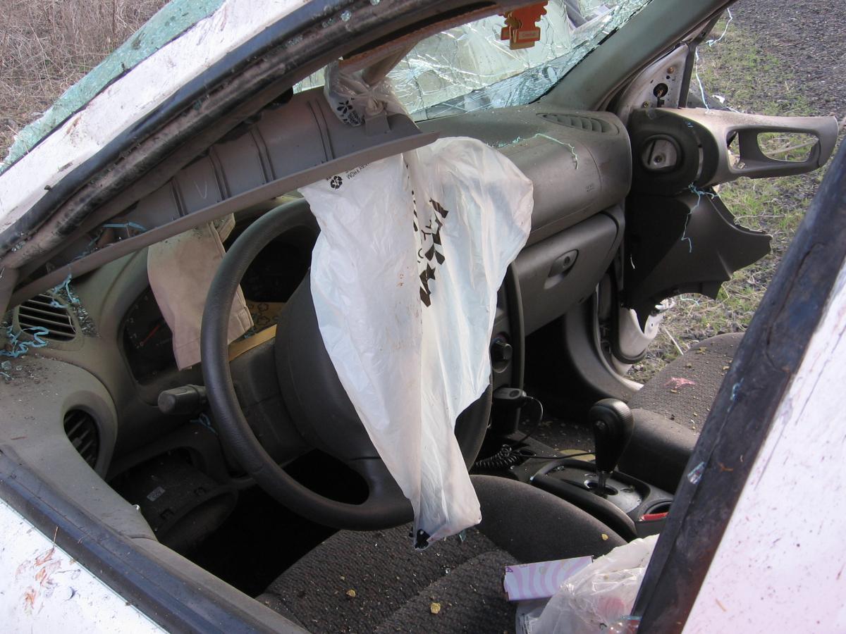 Inside the drivers side of a car with the air bag deployed.