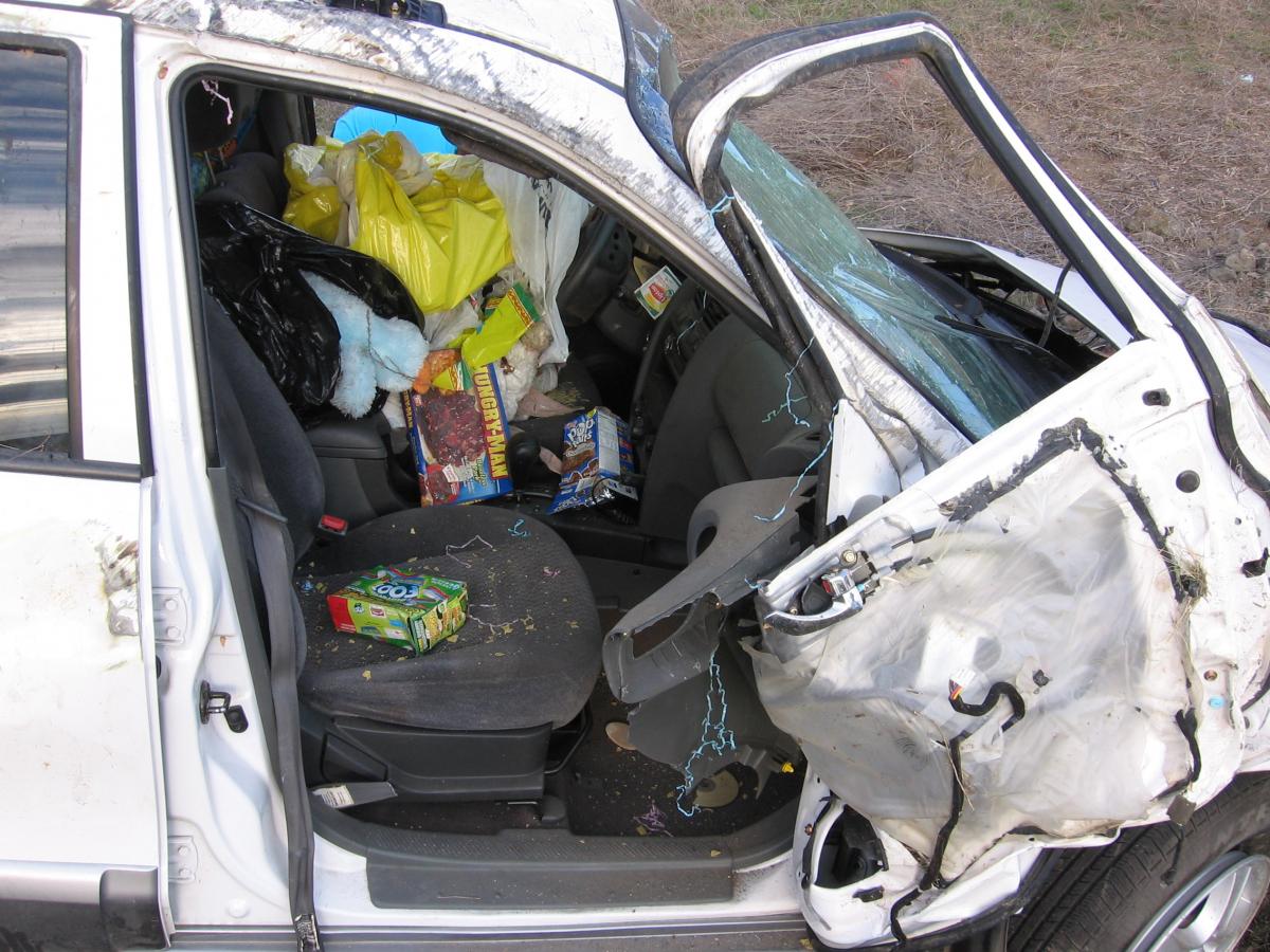 A crashed car with a door bent open.