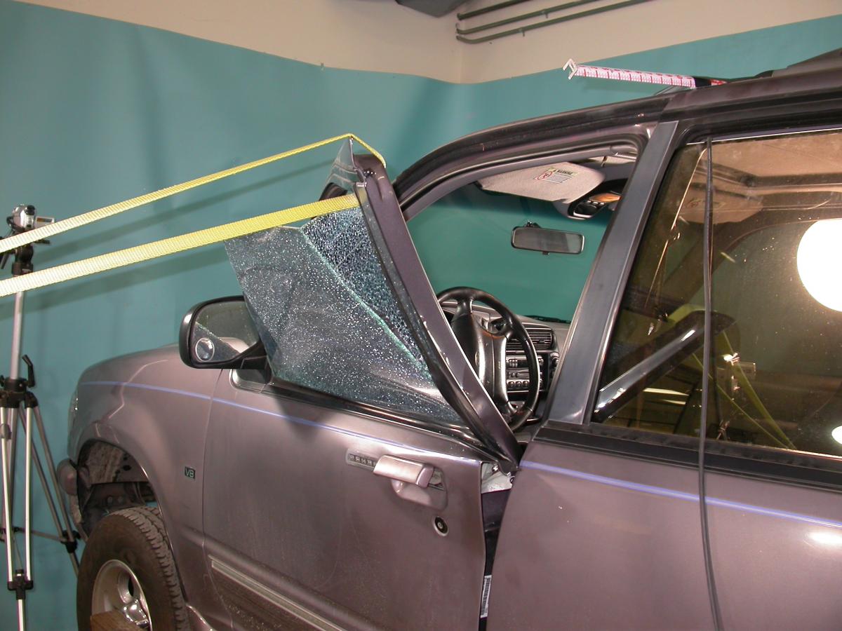A car door being tested but it's window is smashed